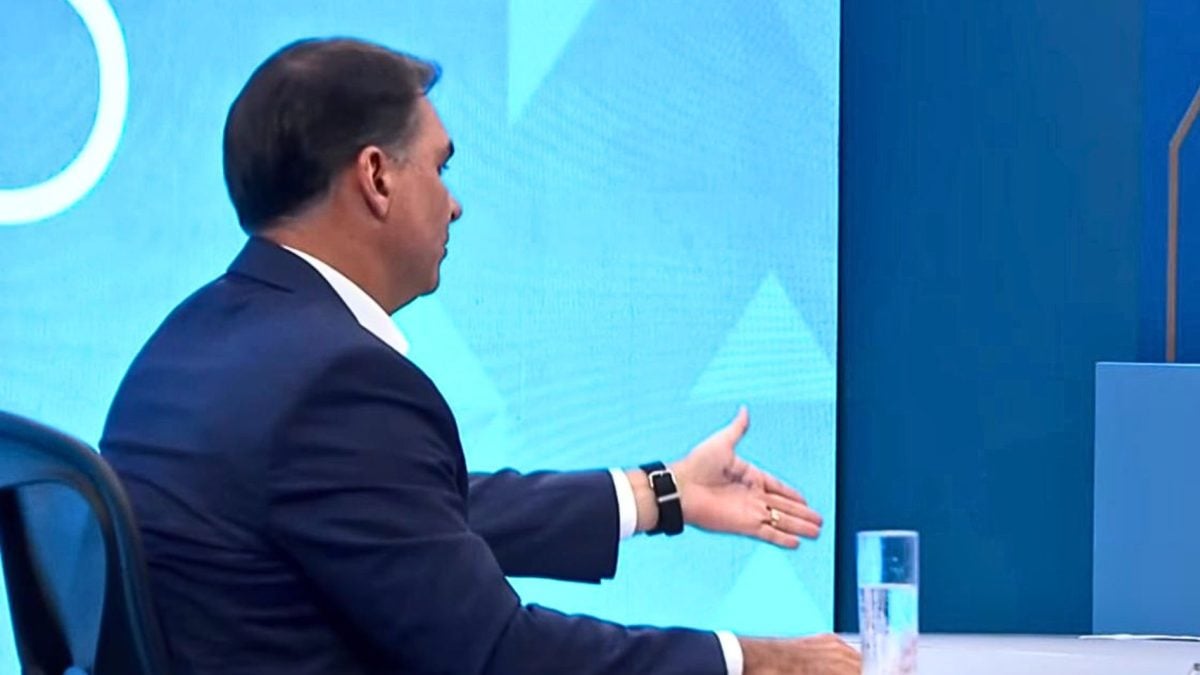 Flávio Bolsonaro adota estratégia do pai e aparece com anotação na mão em entrevista